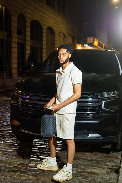 Standing in front of a black SUV under street light